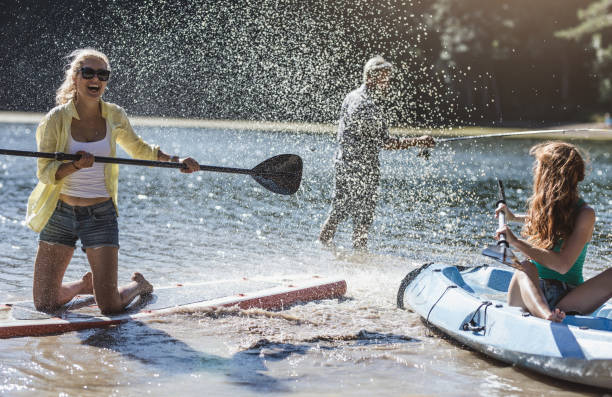 gruppe von freund paddling (sup), rafting auf see - bonding horizontal surfing surf stock-fotos und bilder