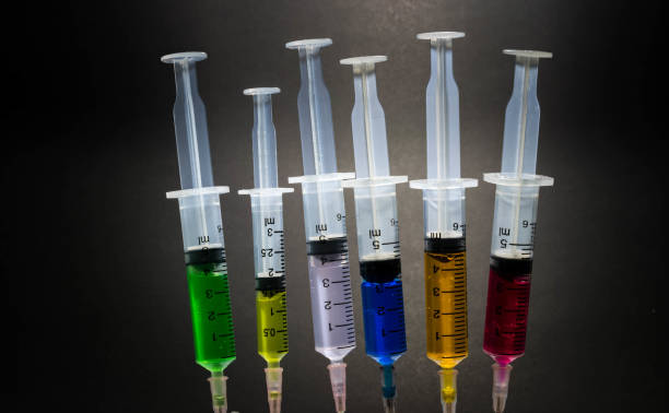 istock Closeup Many multicolor syringes on black background 837504744