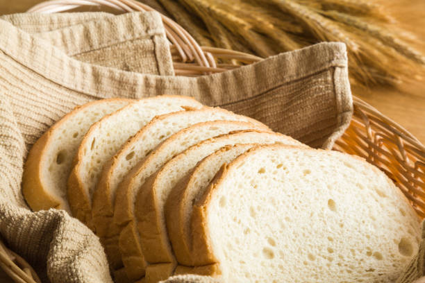 istock Fresh sliced white bread in the basket on the wooden table in the kitchen. Rustic atmosphere. Healthy eating and lifestyle. Food background. Close up. 837505446