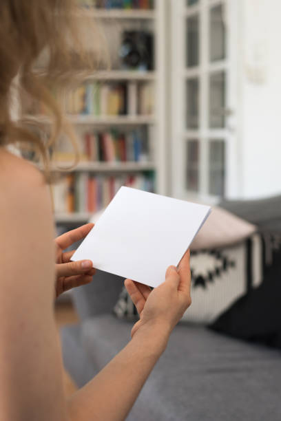 istock Young woman looking at a blank brouchure page with copy space 837505546