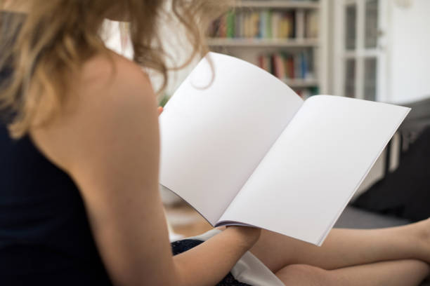 Young woman looking at a blank brouchure page with copy space