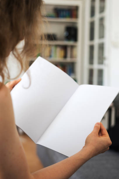 istock Young woman looking at a blank brouchure page with copy space 837505742