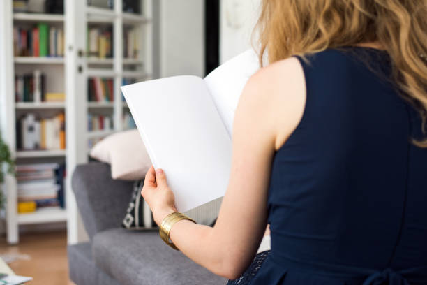 istock Young woman looking at a blank brouchure page with copy space 837505778