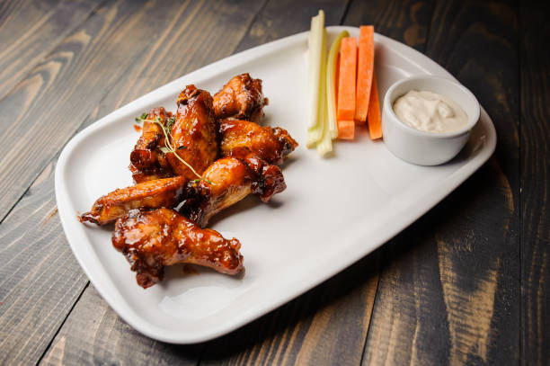 istock Chicken wings baked with carrot and celery close up 837506124