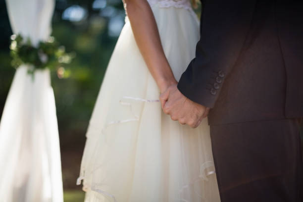 istock Mid section of couple holding hands 837506288