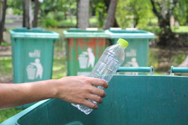 istock Woman hand throwing bottle water into trash can 837507252
