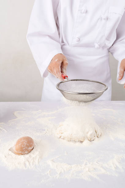 istock young woman sifting flour into bowl at the kitchen 837513316