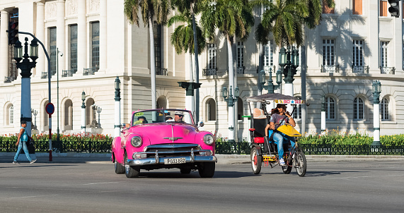 Havana: American pink Chevrolet convertible classic car drive before the Capitolio on the main street in Havana City Cuba - Serie Cuba Reportage
