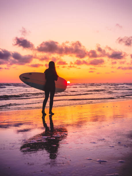 따뜻한 일몰이 나 일출 색상으로 서핑 보드와 서핑 소녀 - women sensuality surfing water sport 뉴스 사진 이미지