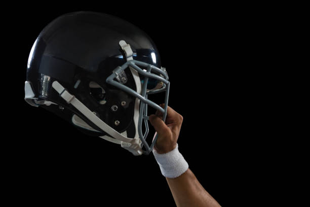 American football sports and team competition. Two American football helmets, one red and one blue, facing each other on a blue background. 3d render.