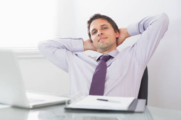 istock Relaxed businessman with hands behind head in office 837549408