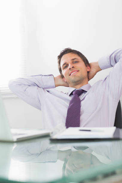 istock Relaxed businessman with hands behind head in office 837549440