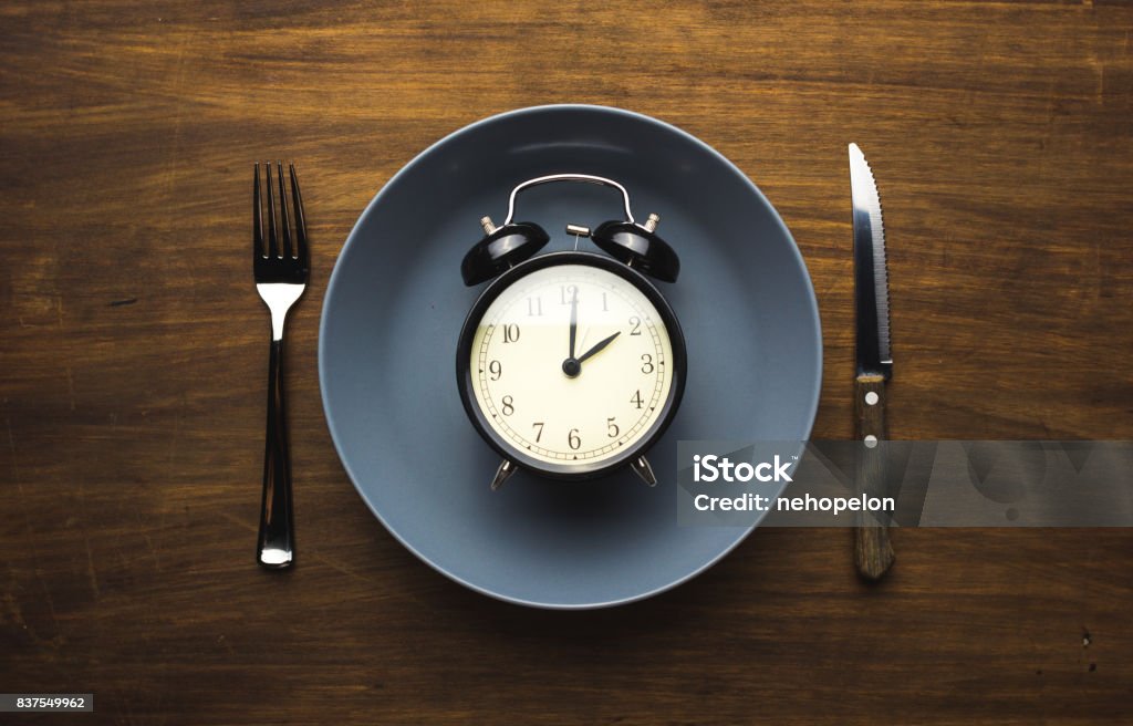 time to eat Alarm clock inside a plate Fasting - Activity Stock Photo