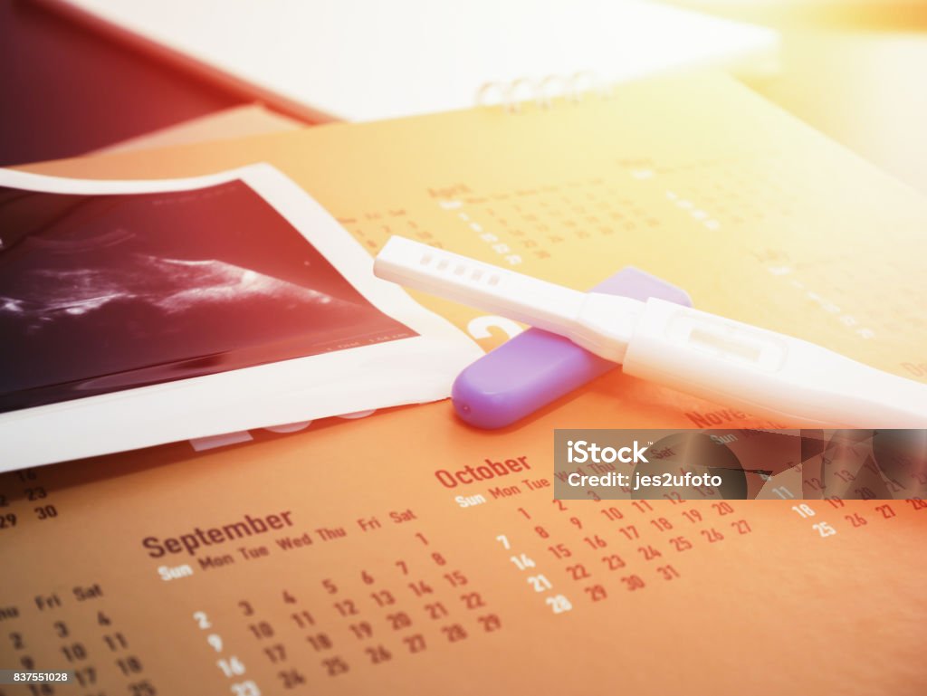 pregnancy test on calendar with ultrasound background pregnancy test on calendar with ultrasound print background Calendar Stock Photo