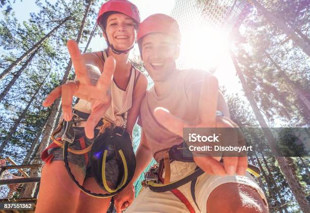 Couple Of Happy Climbers Having Fun In Adventure Park Outdoor Young Friends Doing Extreme Sport Travelwanderlust And Summer Vacation Focus On Faces Warm Filter Stock Photo - Download Image Now
