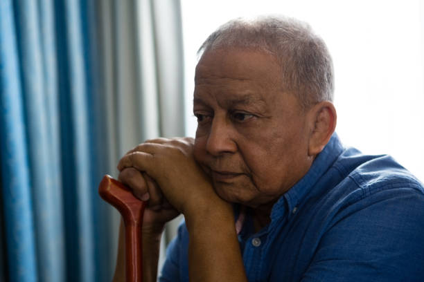 istock Thoughtful senior man with walking cane sitting by window in nursing home 837557252