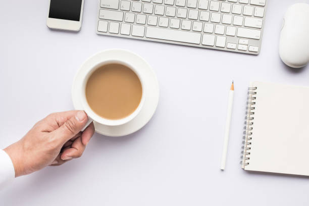 istock Male hand holding coffee cup on white modern working table. 837560002