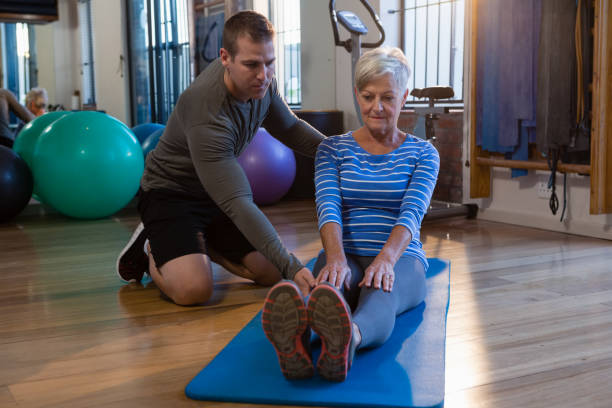 istock Physiotherapist assisting senior woman in exercise 837560144