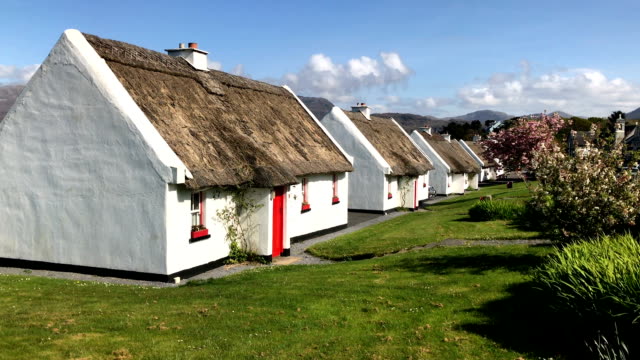 Row of thatched roof cottages in a street in Ireland near Galway