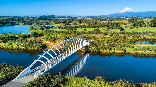 luchtfoto op een mooie brug over een beekje met mount taranaki op de achtergrond. nieuw-zeeland - areal stockfoto's en -beelden