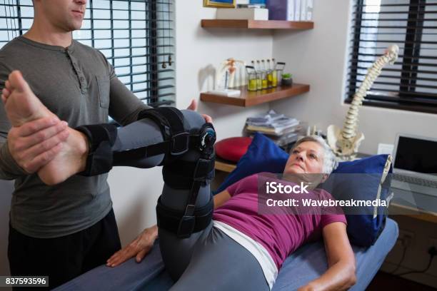 Male Physiotherapist Giving Leg Massage To Patient Stock Photo - Download Image Now - Physical Therapy, Exercising, Senior Adult