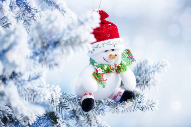 istock Christmas Snowman Hanging on a Snow Tree Branch 837594640