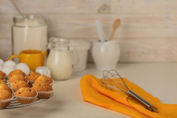 Kitchen utensils, tools and products for the capcake (muffins) on a light wooden background. Selective focus.