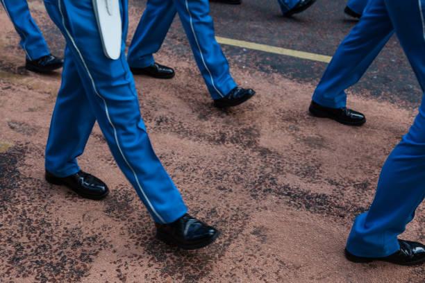 Troop of royal guards marching with a drum in close-up on textured pavement with dramatic shadows in London, England, UK