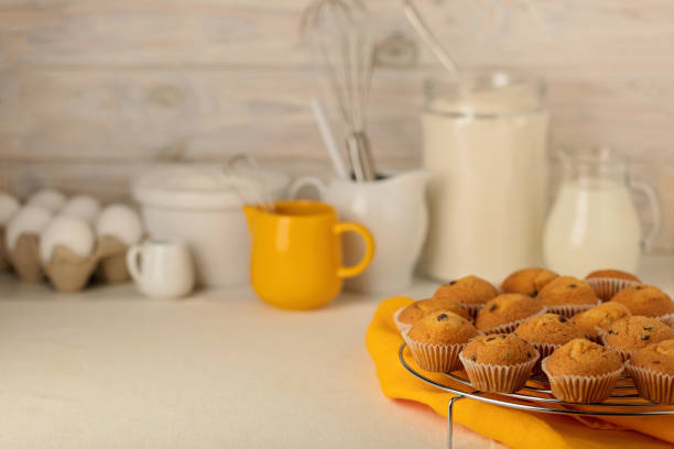 Kitchen utensils, tools and products for the capcake (muffins) on a light wooden background. Selective focus.