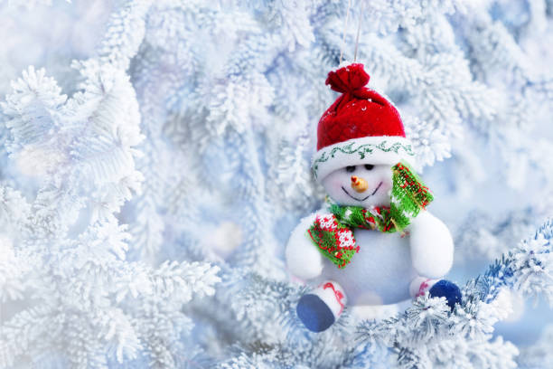 istock Christmas Snowman Hanging on a Snow Tree Branch 837604258