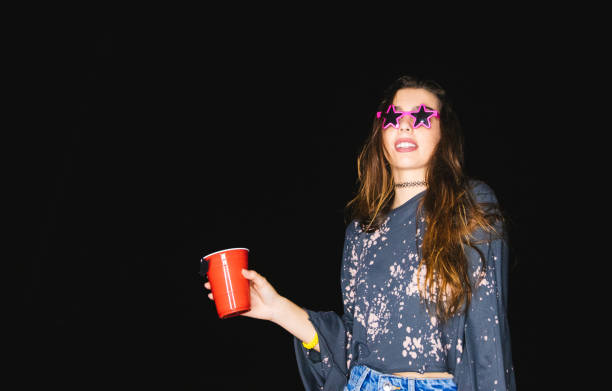 młoda kobieta pijąca i imprezująca z zabawnymi okularami przeciwsłonecznymi w nocy - 2347 zdjęcia i obrazy z banku zdjęć