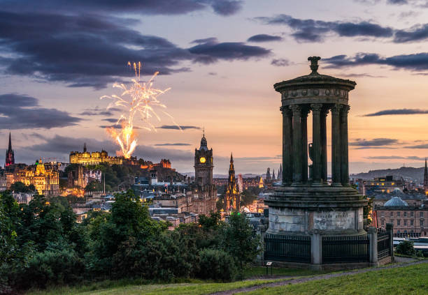 Edinburgh fireworks at dusk from Calton Hill Fireworks over the Edinburgh skyline, as seen from Calton Hill. hogmanay photos stock pictures, royalty-free photos & images