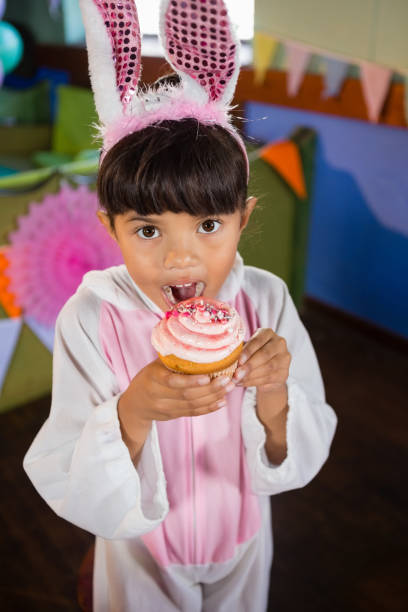 istock Girl having cupcake during birthday party at home 837605896