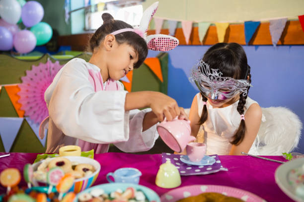 istock Kids playing with tea set during birthday party 837606278