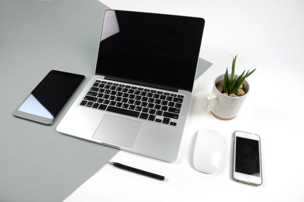istock Office table with  laptop computer, notebook, digital tablet and smartphone on modern two tone (white and grey) background. 837607686