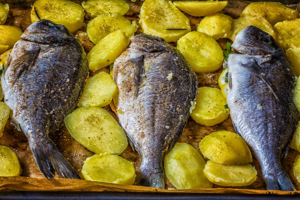 istock Raw fish Dorado with fresh potatoes ready to baking 837631722
