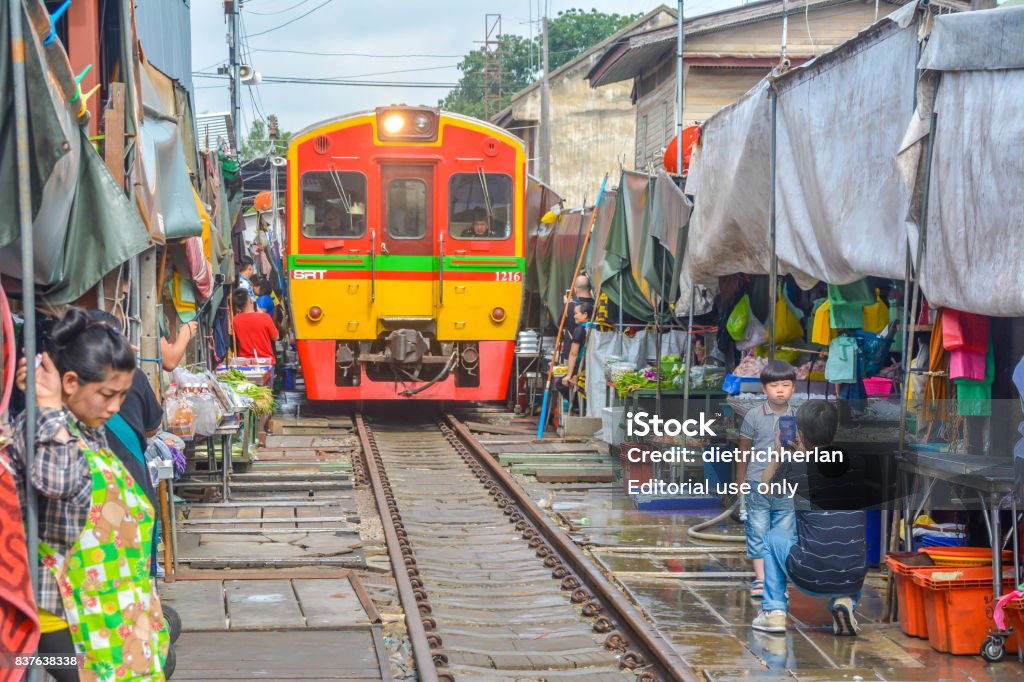 Train Market in Maeklong in Thailand Samut Songkhram Province, Thailand - August 08, 2017: People are picked up the food for dodge the train are traveling across the market in Maeklong market,Thailand. Market - Retail Space Stock Photo