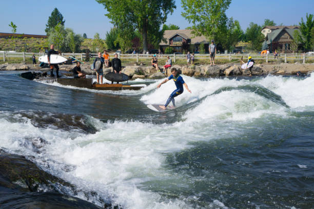 Munich, Germany - October 13, 2023: Surfer in the city river, Munich is famous for people surfing in urban enviroment called Eisbach