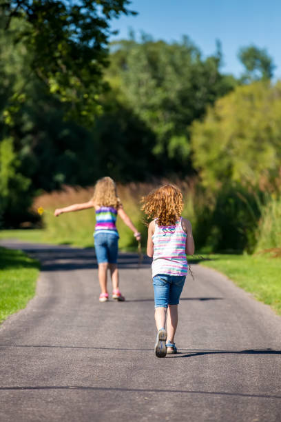 istock Girls Walking Along Paved Path in Late Summer 837647998