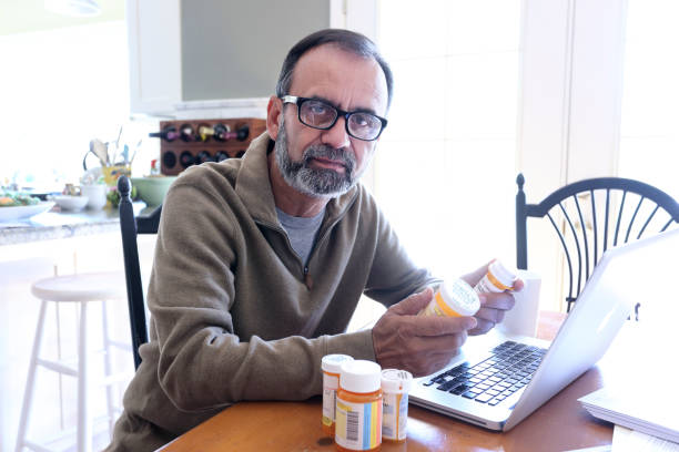 istock Hispanic Man Looks At Camera While Checking His Prescription Medications 837648180