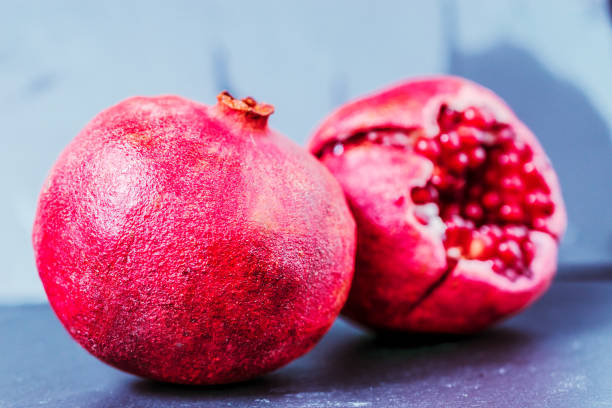 whole and cut pomegranate on dark vintage background  with copy space - usa restaurant flower bed beauty in nature imagens e fotografias de stock