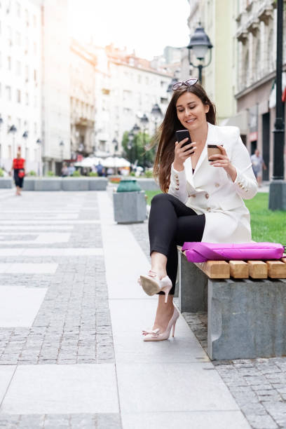 istock Businesswoman sitting on a bench and using a phone 837670188
