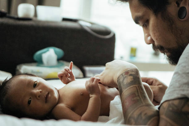 istock Father changing baby boy (0-1 months) on bed 837671344