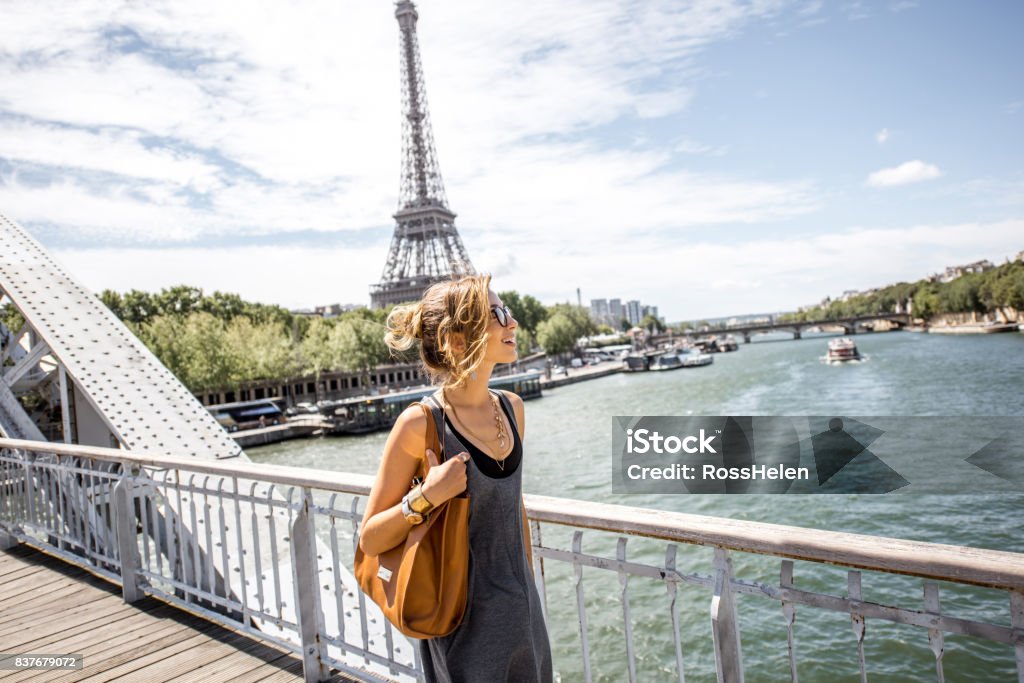 Woman walking in Paris Elegant french business woman walking the bridge with Eiffel tower on the background during the sunny weather in Paris Paris - France Stock Photo