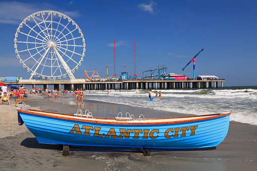 ATLANTIC CITY, NEW JERSEY - AUGUST 19, 2017: Boat lifeguard, beach and steel Pier in Atlantic City. Established in the 1800s as a health resort, today the city is dotted with modern high-rise hotels.