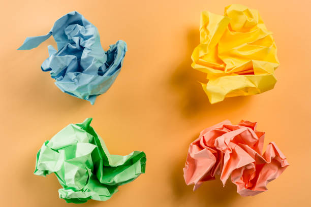 istock Crumpled multi colored paper ball on a plain paper 837705562