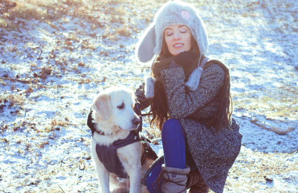 woman,golden retriever,dog,winter,cold,nature,walk,portrait,love,friendship,snow,wind