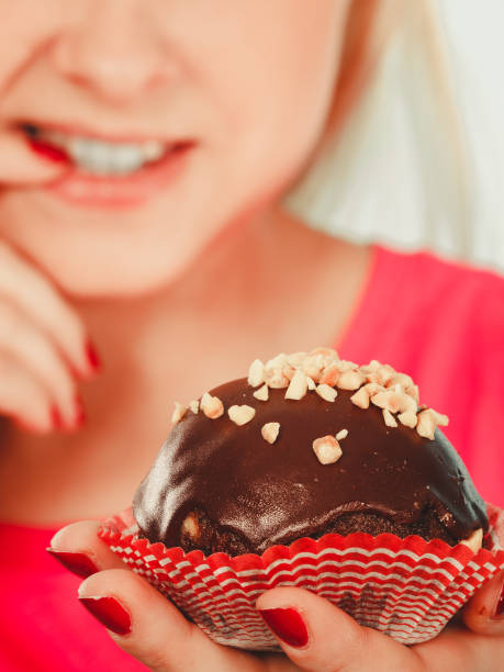 istock Cute blonde woman thinking about eating cupcake 837742022