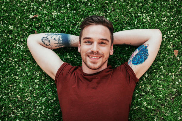 istock Happy Eastern European young man relaxing in park on green grass 837745480