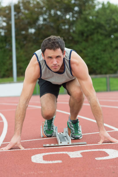 istock Young man ready to race on running track 837769266